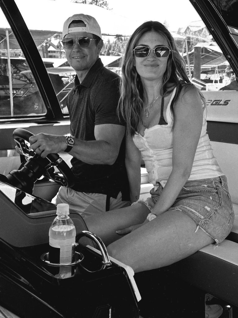 black and white photo mark wahlberg rhea durham sitting behind wheel of boat