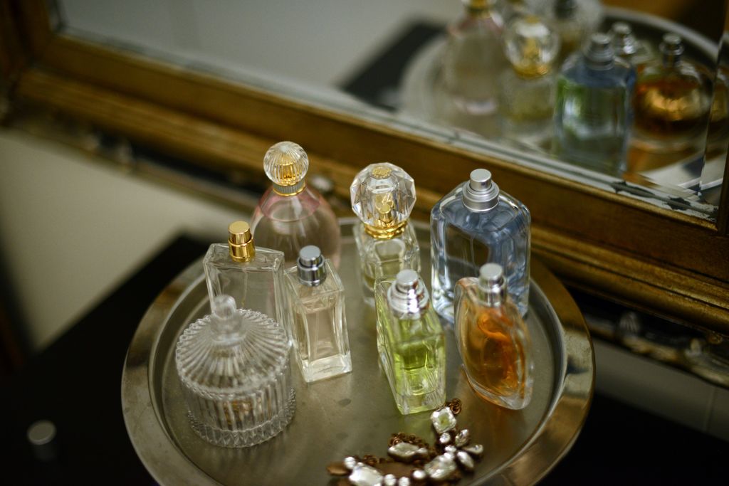 Perfume bottles on a silver tray by an antique mirror