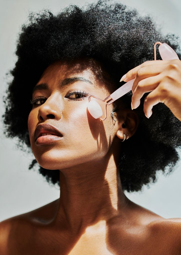 Model with flawless skin using rose quartz roller 