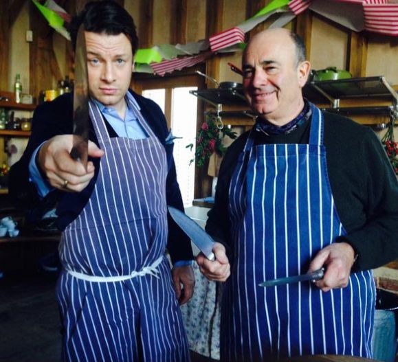 Jamie Oliver and father in aprons holding knives