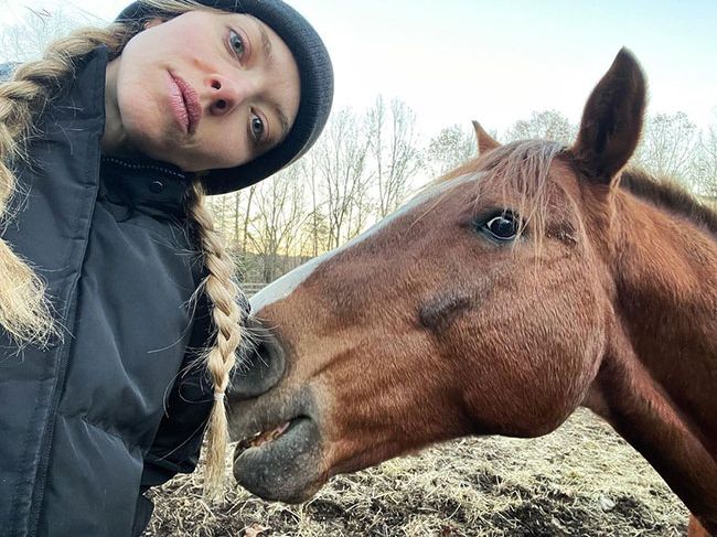 Amanda Seyfried poses for a photo with a horse from her farm