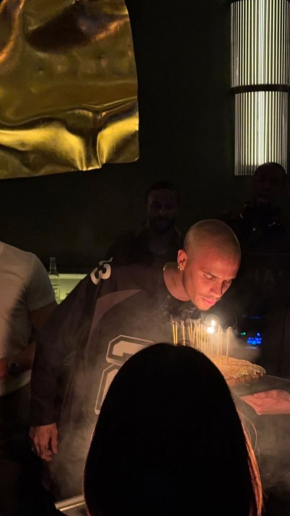 A photo of a man blowing out candles on a birthday cake 