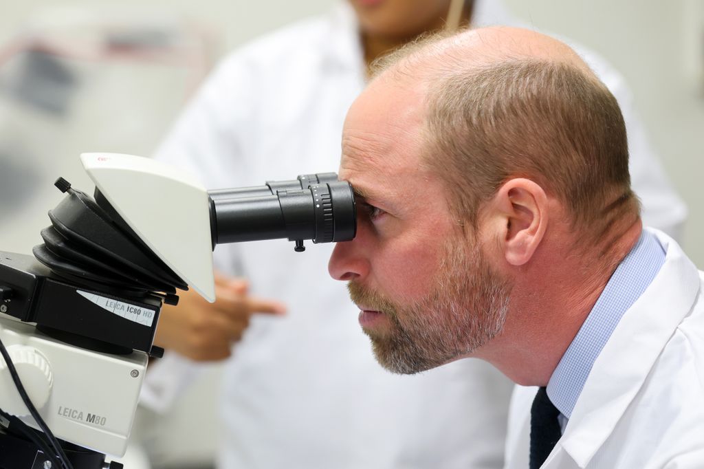 Фотография принца Уильяма, смотрящего в микроскоп