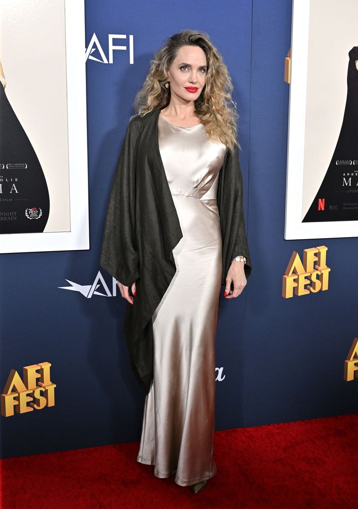 woman posing for photos in gold slip dress