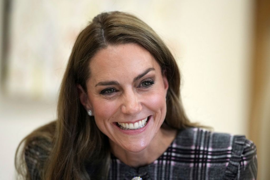 Kate Middleton smiling in checked dress
