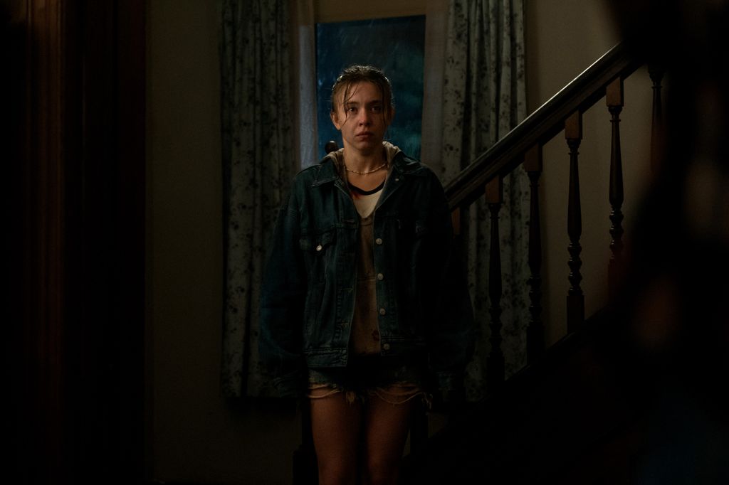 woman standing in dimly-lit hallway