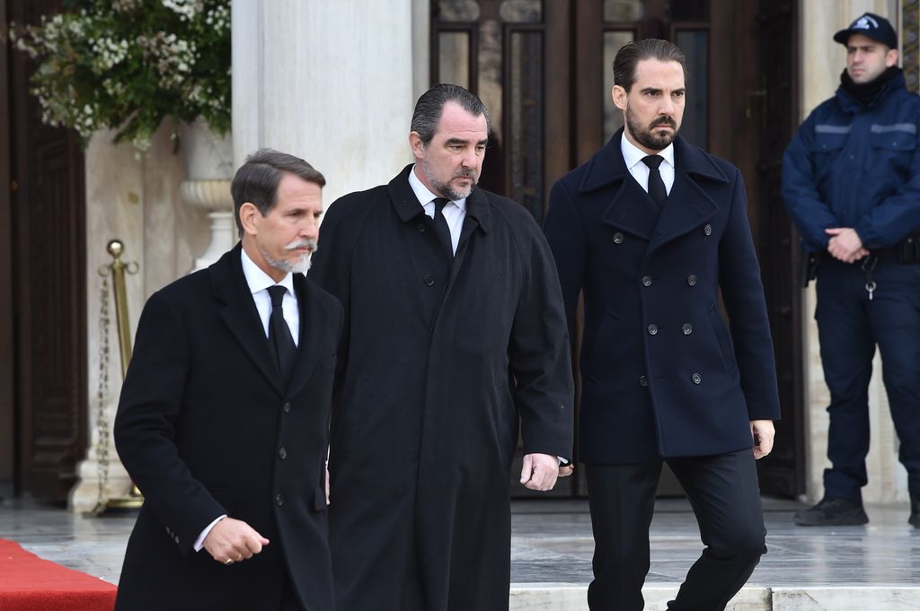 Pavlos, Crown Prince of Greece, Prince Nikolaos of Greece and Prince Philippos of Greece in black suits and coats