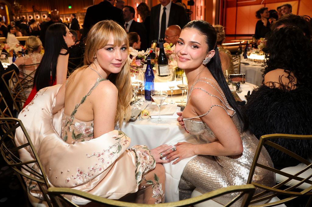Jennifer Lawrence and Kylie Jenner smiling over their shoulders at the Golden Globe Awards