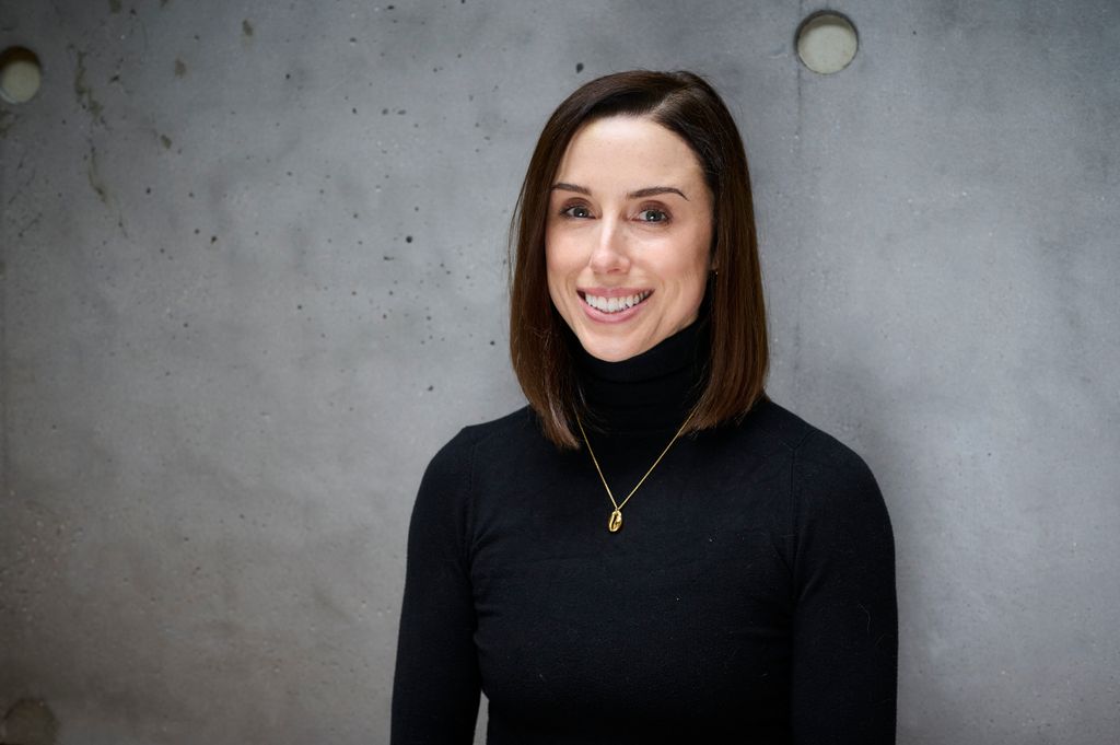 Woman in a black polo shirt with brunette hair