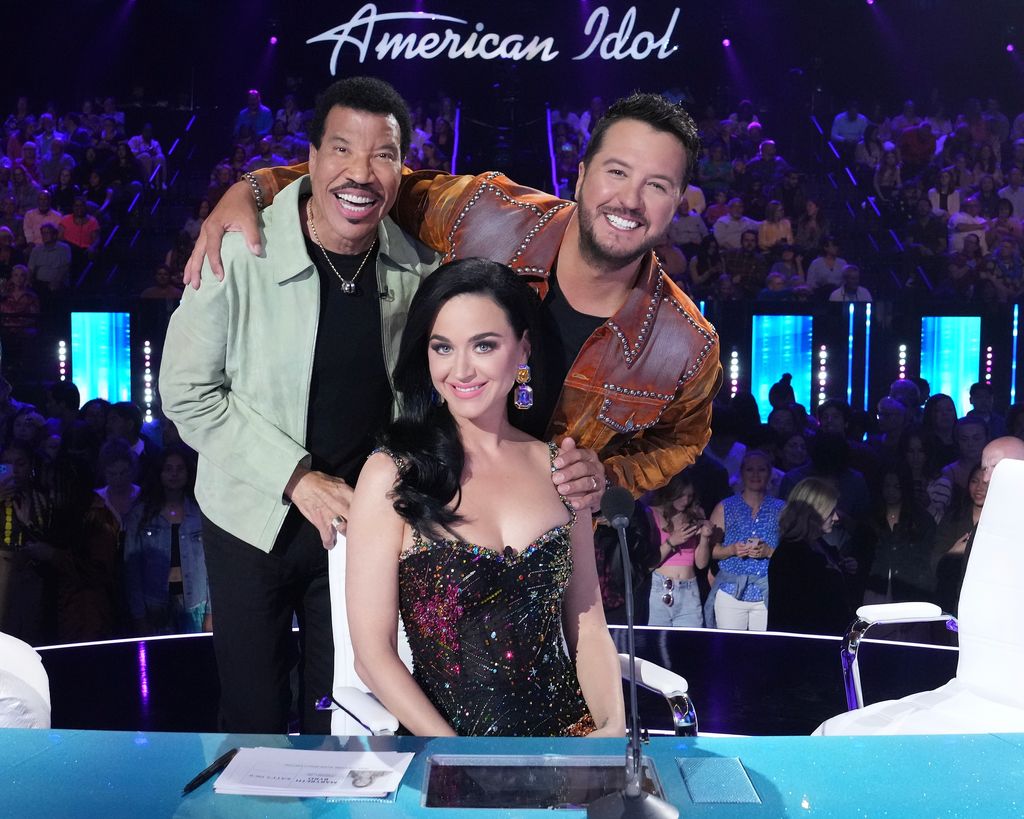 The singer smiling with her fellow Idol judges Lionel and Luke stood behind her