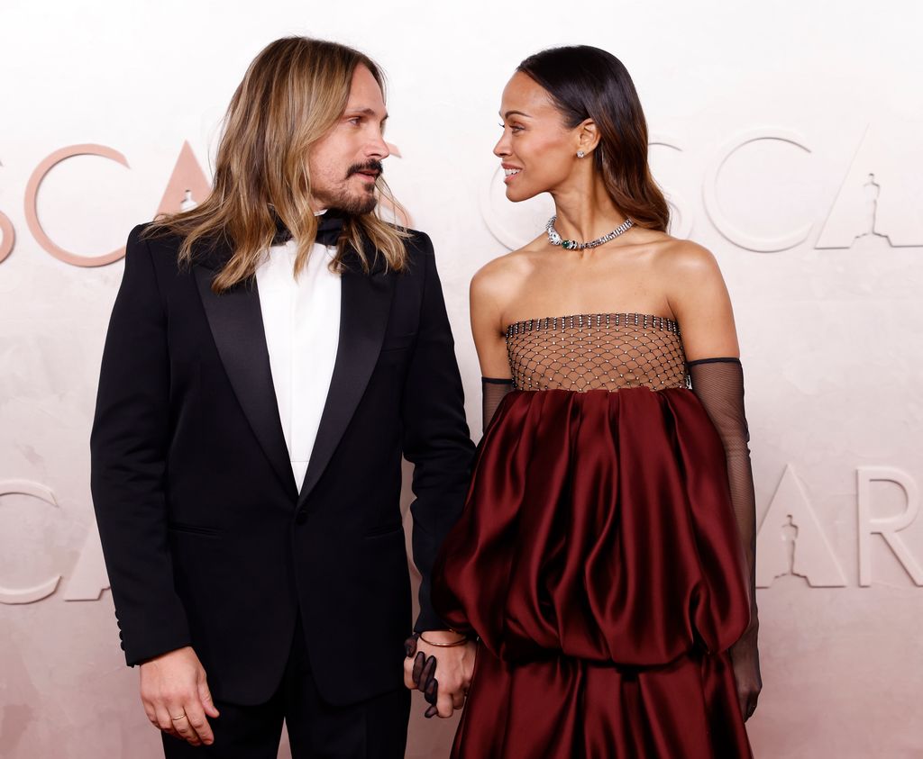 Marco Perego-Saldaña and Zoe Saldaña looking at each other while on the red carpet arrive for the 97th Academy Awards in the Hollywood section of Los Angeles on Sunday, March 2, 2025