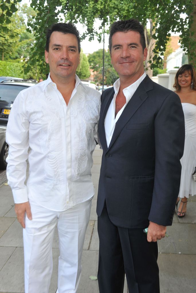 Nicholas Cowell in a white suit with Simon Cowell in a grey suit