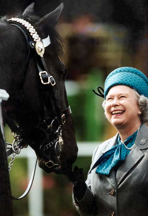 the queen looking delightedly at a horse