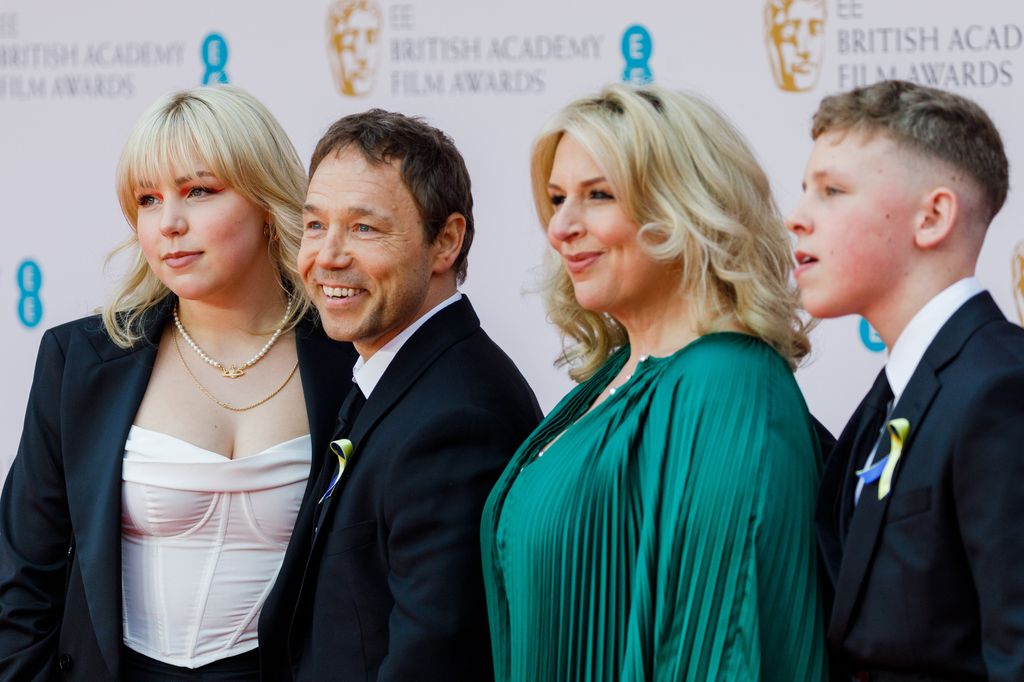 Hannah Walters and Stephen Graham pose with children at the EE British Academy Film Awards 2022 