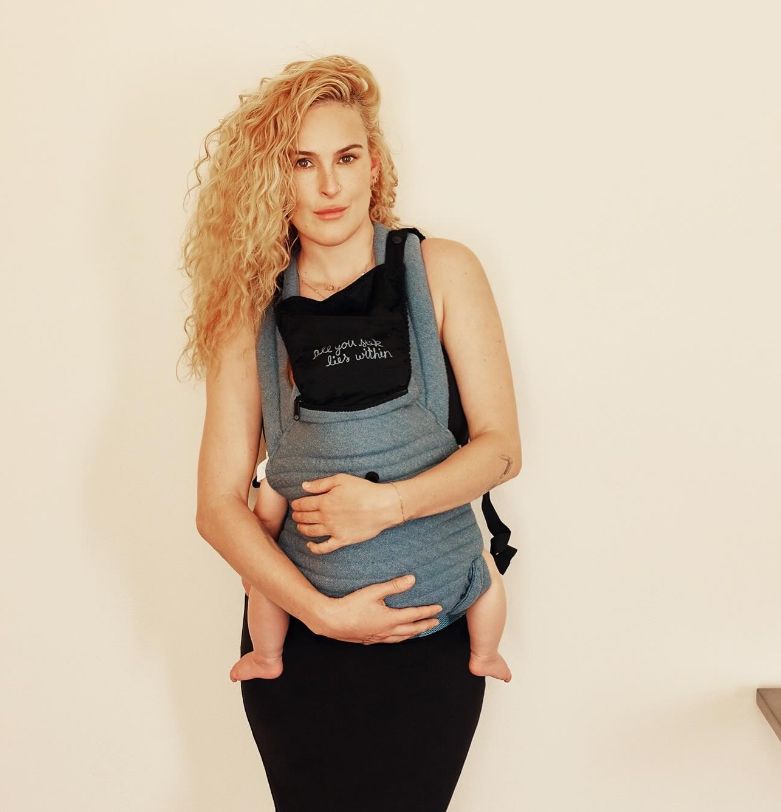 Rumer Willis holding a baby in a baby carrier