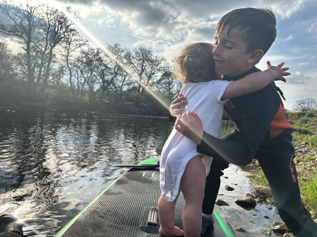 Helen Skelton's son Ernie helping his little sister Elsie on a paddleboard