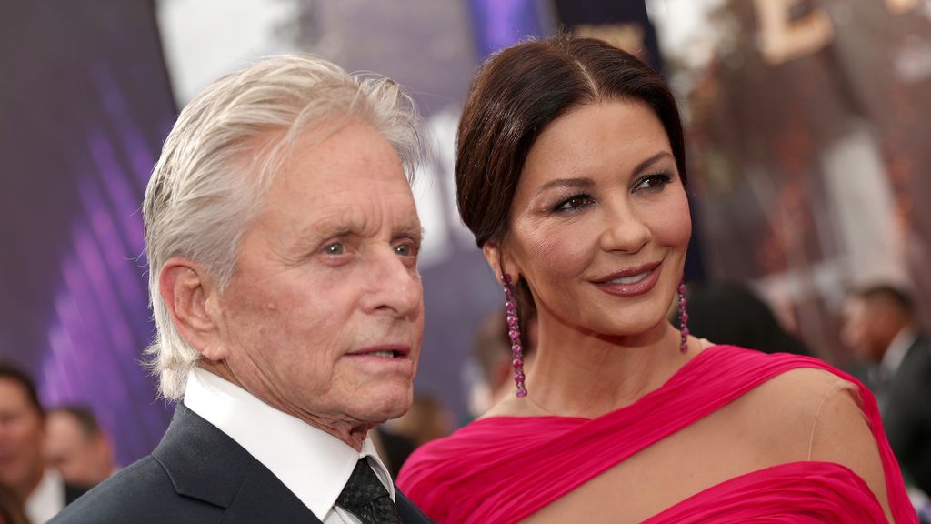 Catherine Zeta-Jones wearing a pink gown and Michael Douglas in a suit at a red carpet event
