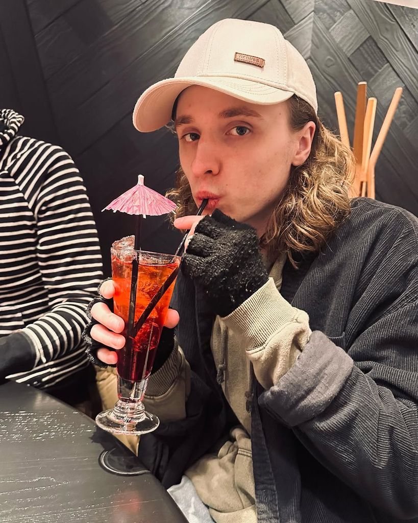 Ty Tennant sipping a cocktail in a cap