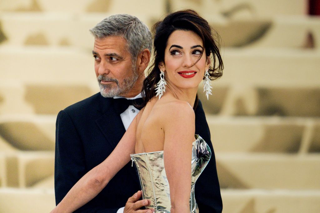 O ator George Clooney e a advogada Amal Clooney entram na Gala do Heavenly Bodies: Fashion and the Catholic Imagination Costume Institute no Metropolitan Museum em 7 de maio de 2018 na cidade de Nova York.