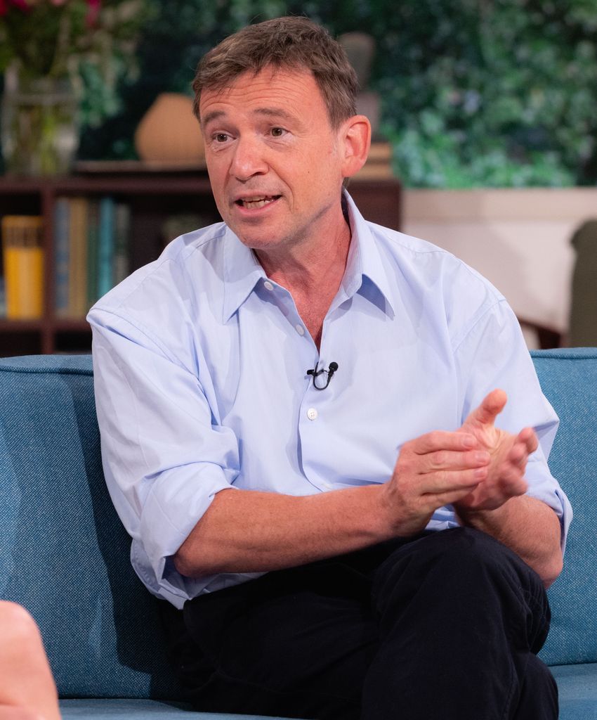 man in blue shirt sitting on blue sofa