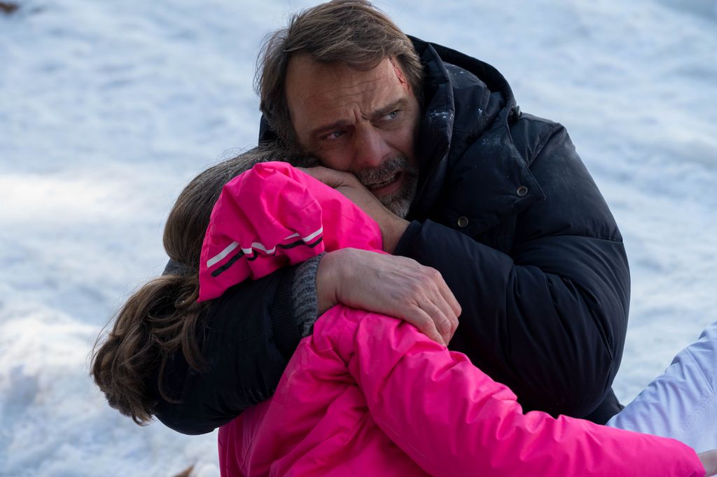 man hugging little girl in snow