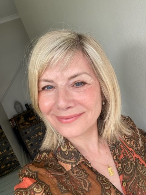 Woman smiling in a brown printed shirt