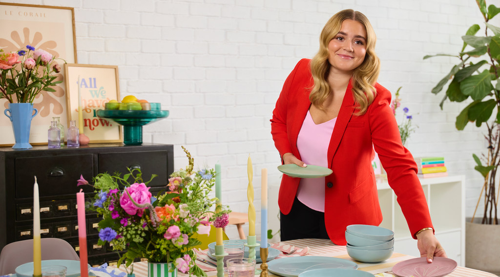 Tilly in red jacket laying table