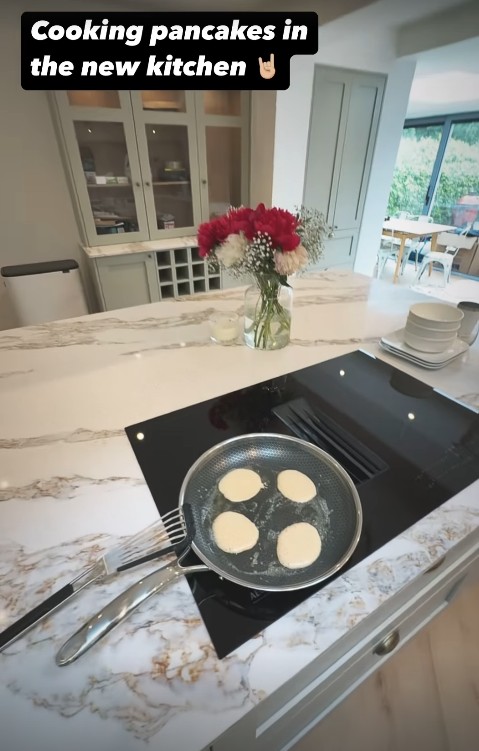 Image de crêpes sur la cuisinière du four avec de la crème élégante et une cuisine turquoise en arrière-plan