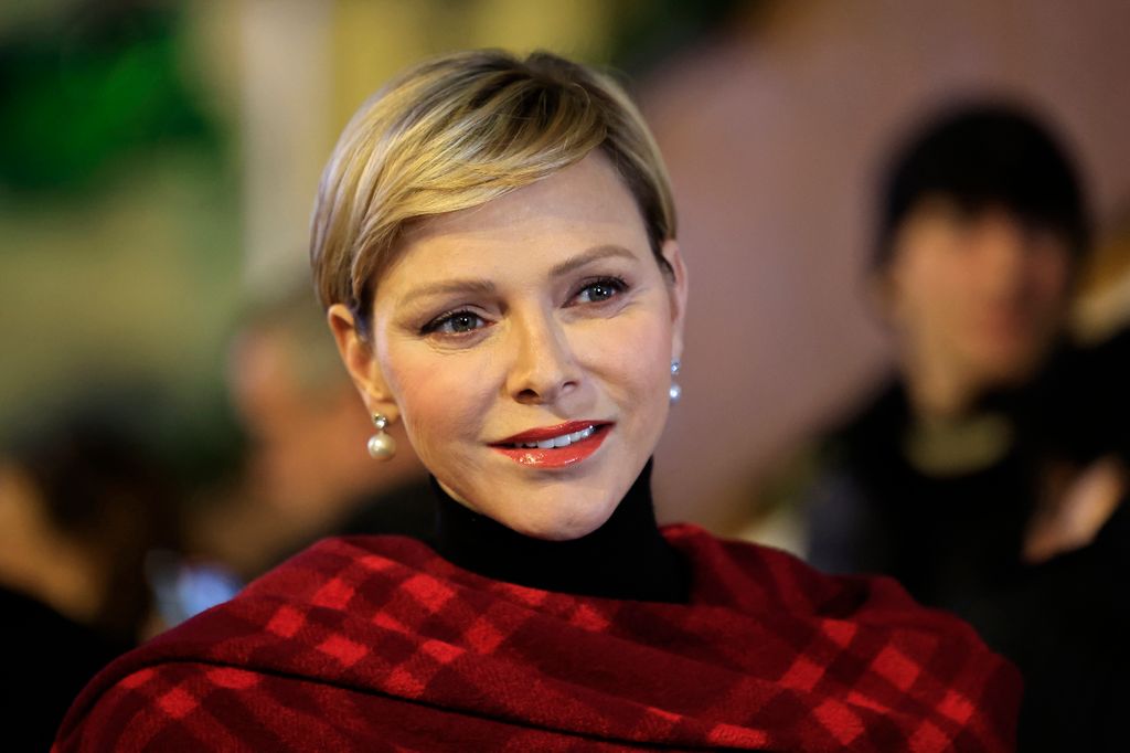 Princess Charlene in red and black check shawl