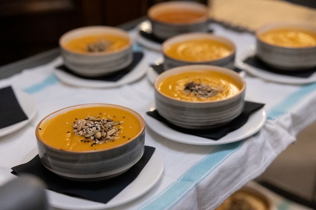 Bowls of orange soup with nuts on top