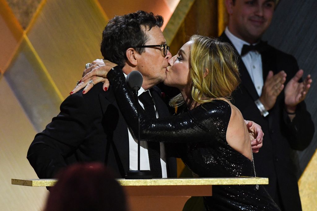 Honoree Canadian-American actor Michael J. Fox kisses his wife Tracy Pollan as he accepts the Jean Hersholt Humanitarian Award during the Academy of Motion Picture Arts and Sciences' 13th Annual Governors Awards at the Fairmont Century Plaza in Los Angeles on November 19, 2022