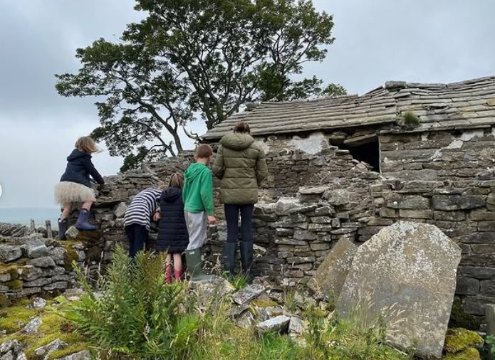 A group of children standing behind a stone wall