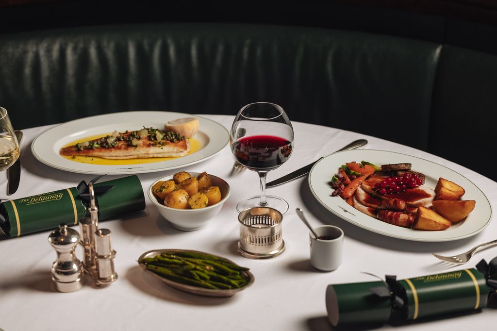 food and red wine on table with black sofa seating