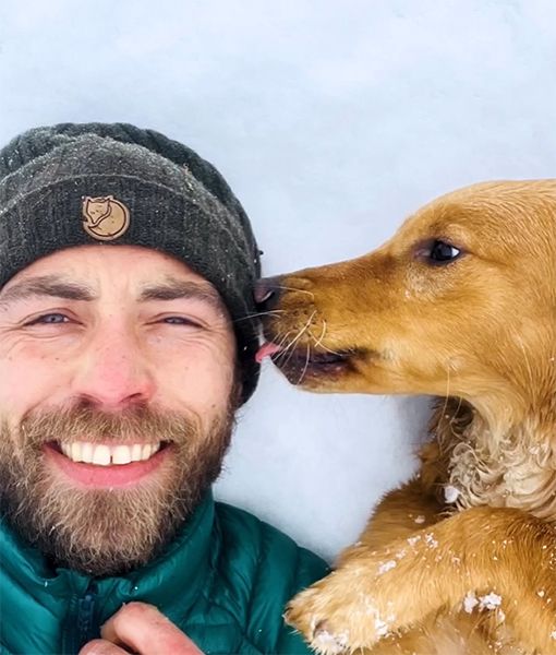 James Middleton and dog lying in the snow