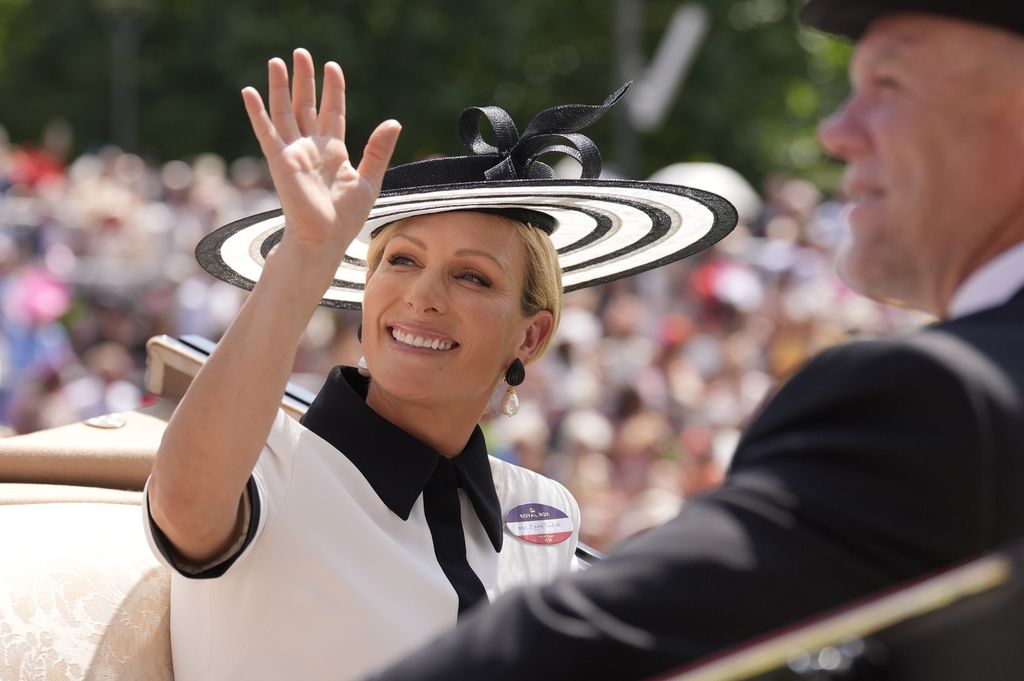 Zara Tindall waving from carriage in black and white dress and hat