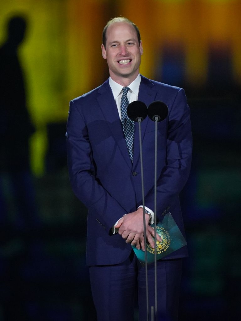 Prince William smiling on stage during the concert