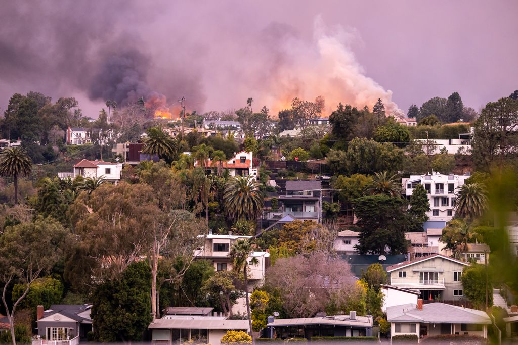 Flames from the Palisades Fire approach homes on January 08, 2025 in Pacific Palisades, California