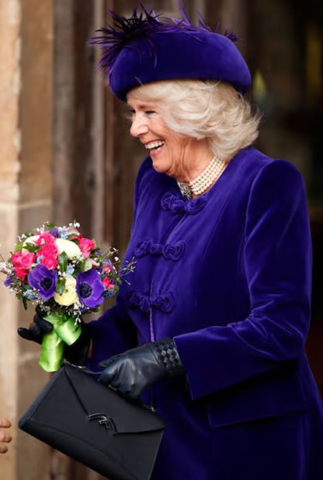 queen camilla wears purple jacekt and hat