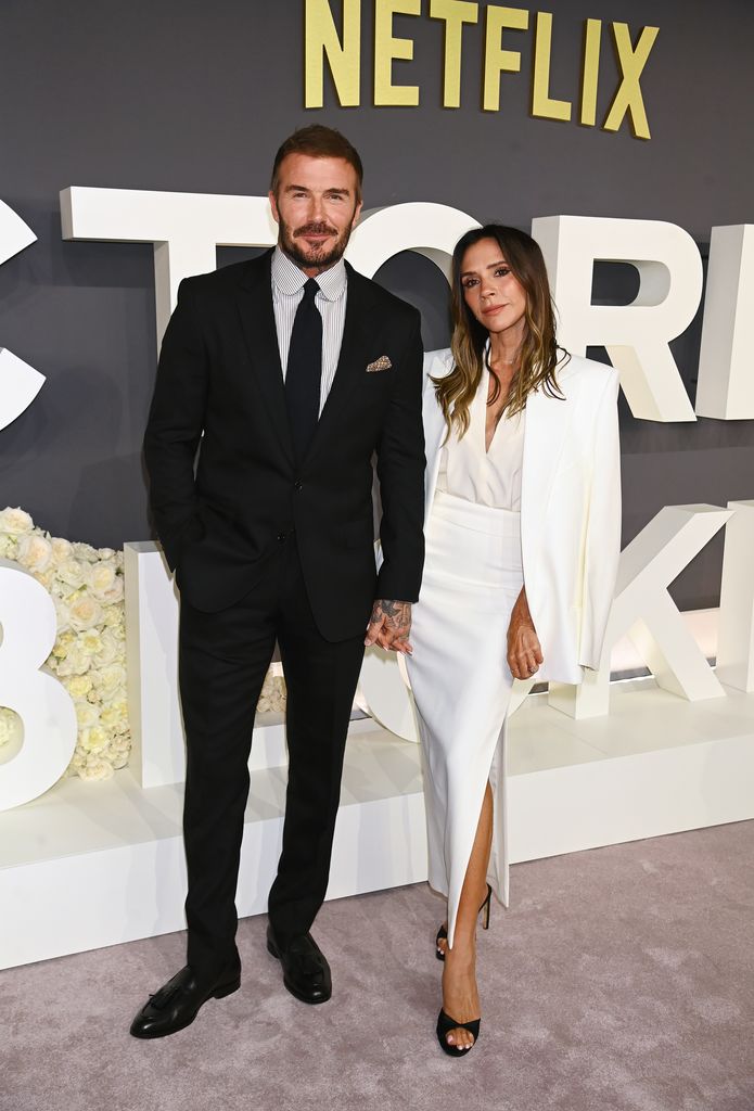 David Beckham and Victoria Beckham hold hands and pose for photos as they attend the World Premiere of "Victoria Beckham" at The Curzon Mayfair on October 8, 2025 in London, England