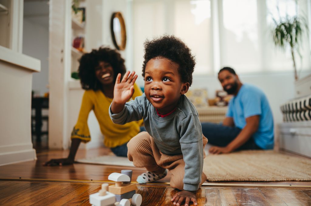 happy toddler playing with mother and father