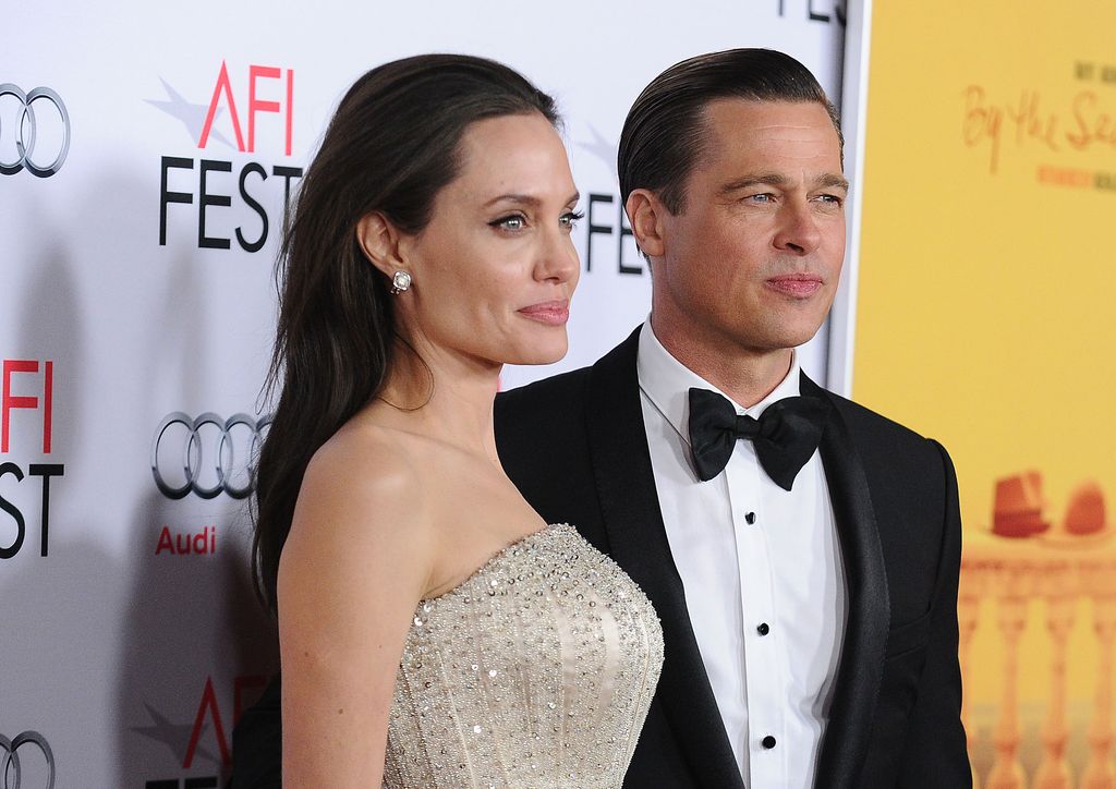 Brad Pitt wearing a black tuxedo and Angelina Jolie wearing a sparkly dress