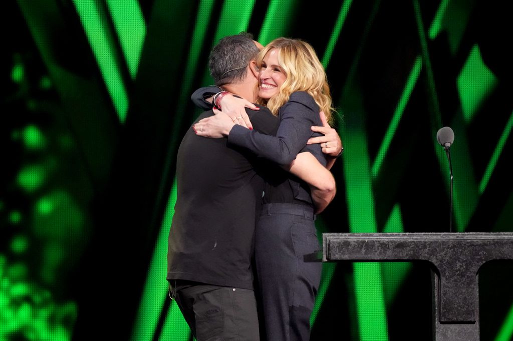   Dave Matthews, miembro de Dave Matthews Band, abraza a Julia Roberts en el escenario 