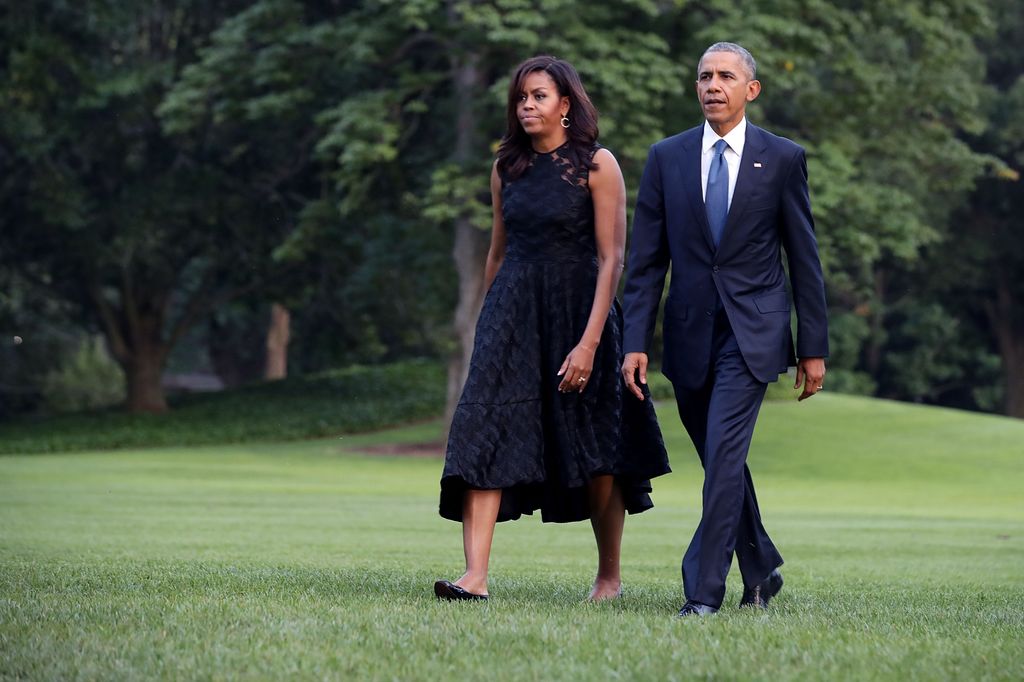 U.S. President Barack Obama (R) and first lady Michelle Obama walk across the South Lawn after returning to the White House on Marine One July 12, 2016 in Washington, DC. The Obamas were returning from Dallas where they attended a public memorial service for the five Dallas police officers who were killed by a sniper last week during a Black Lives Matter demonstration.  (Photo by Chip Somodevilla/Getty Images)