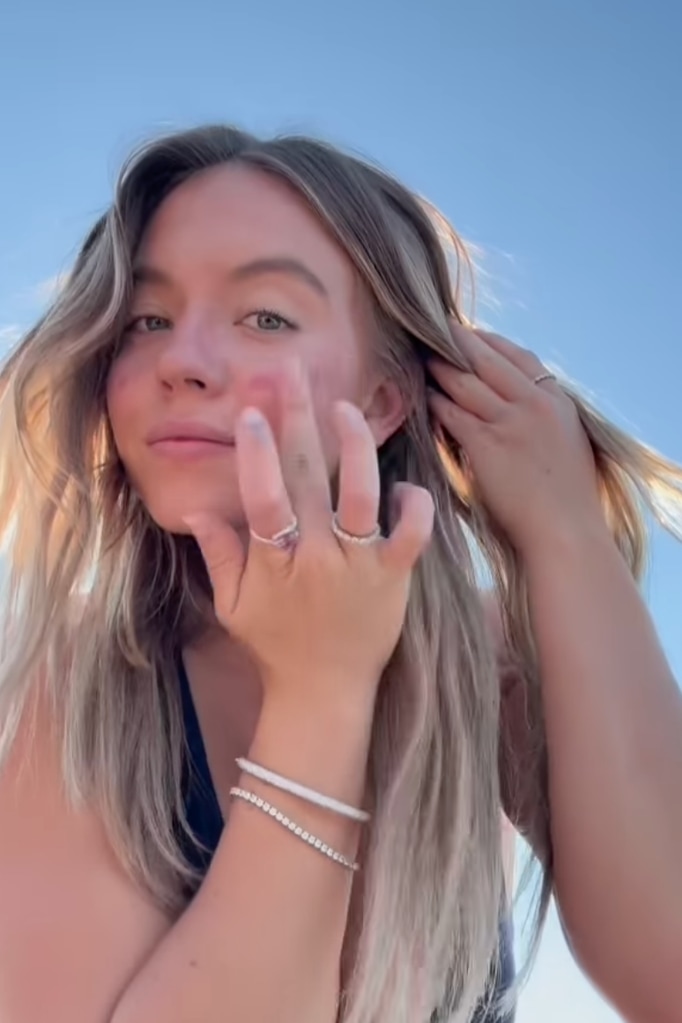 The actress gently applies blush with her fingers