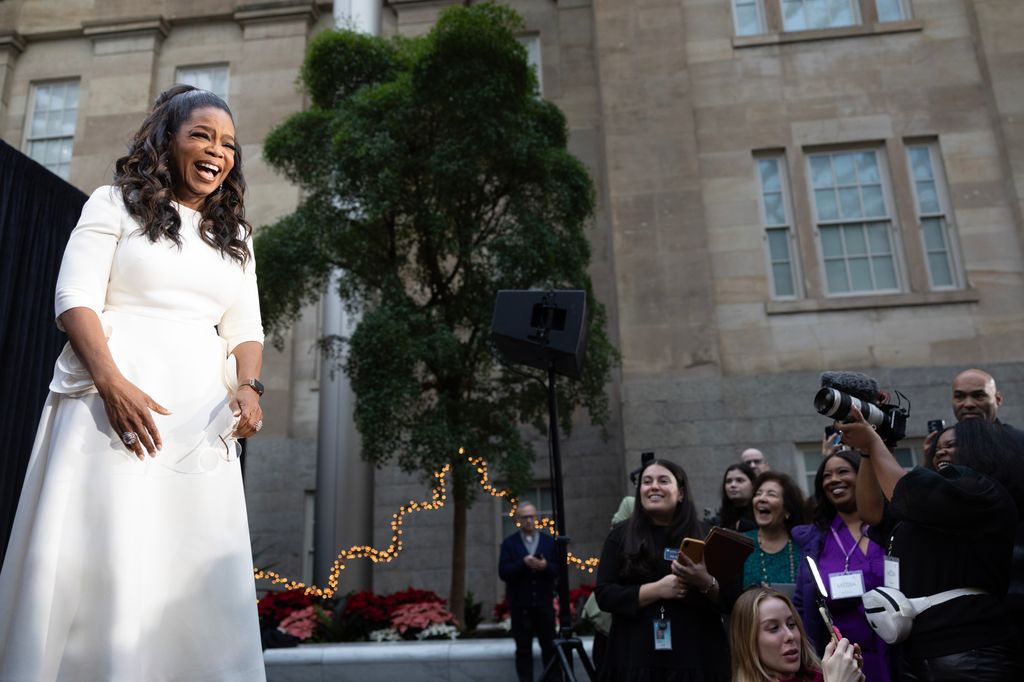 Oprah in white in front of crowd