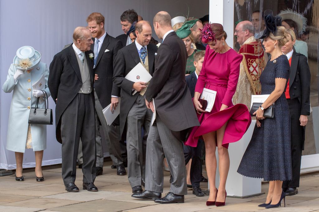Princess Kate holding down her skirt in the wind as Duchess Sophie looks on with amusement