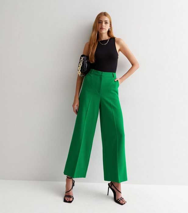 model wearing cropped green wide legged trousers