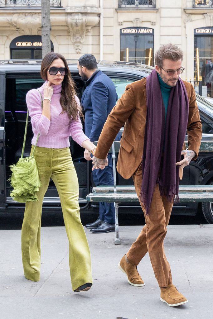 David and Victoria holding hands in chic outfits 