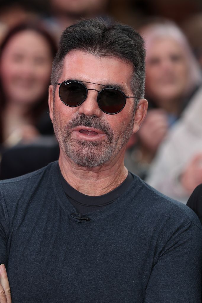 Simon Cowell wearing sunglasses and a dark grey tshirt