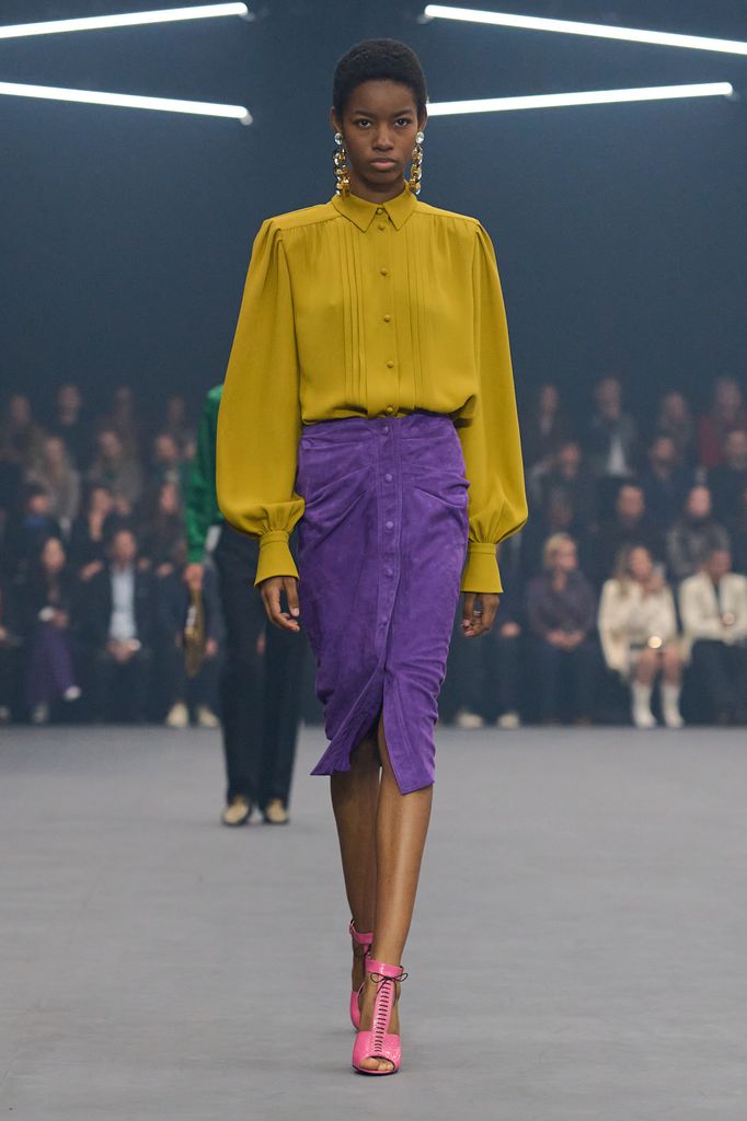 Valentino SS26, a model walks down the runway in a yellow blouse, purple skirt and pink heels 